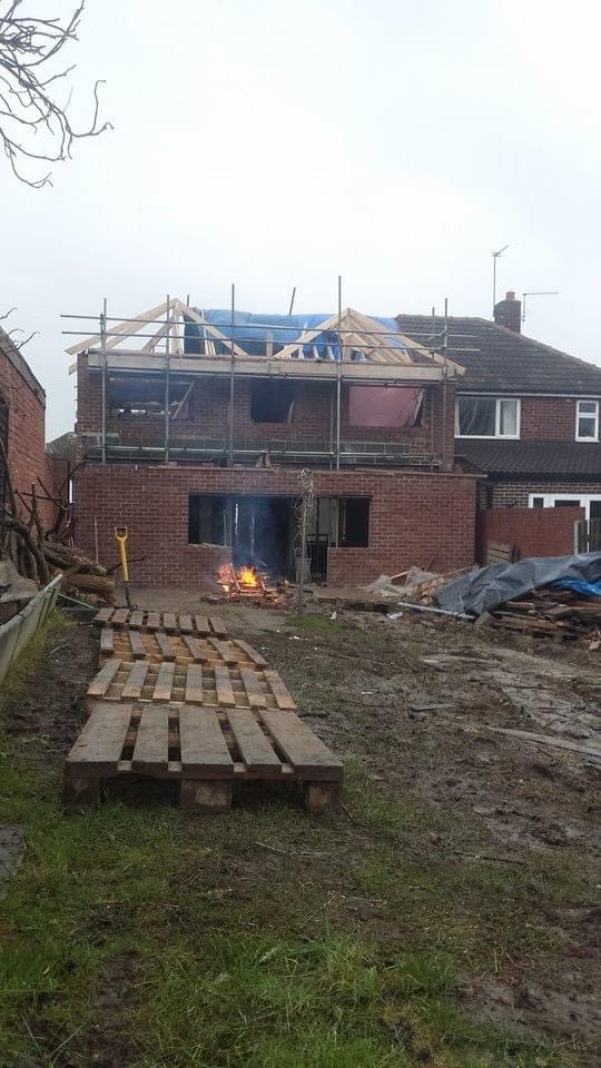 Timber roof framework being built over a two-storey rear extension