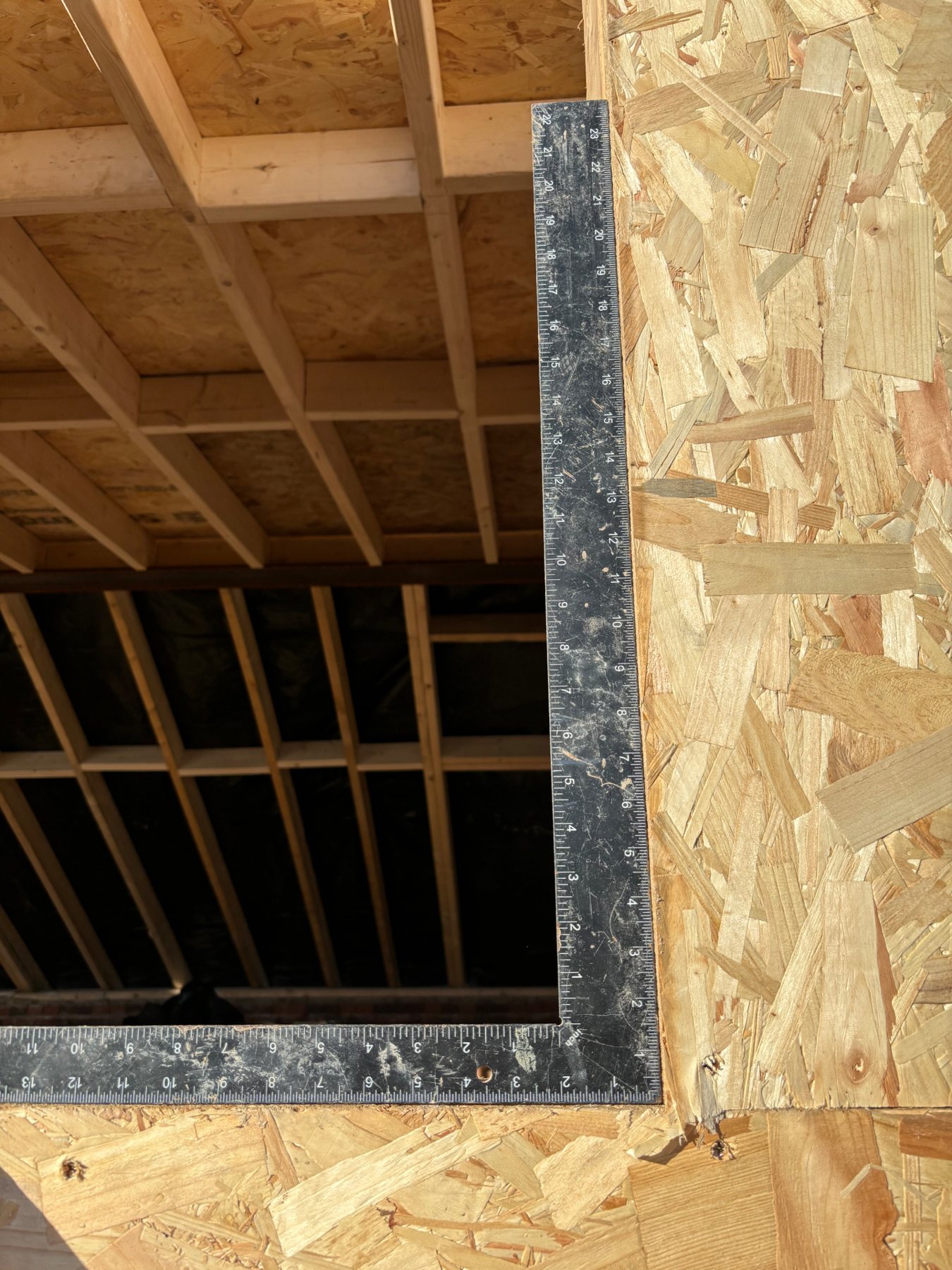Roofing square checking a structural opening is true and plumb