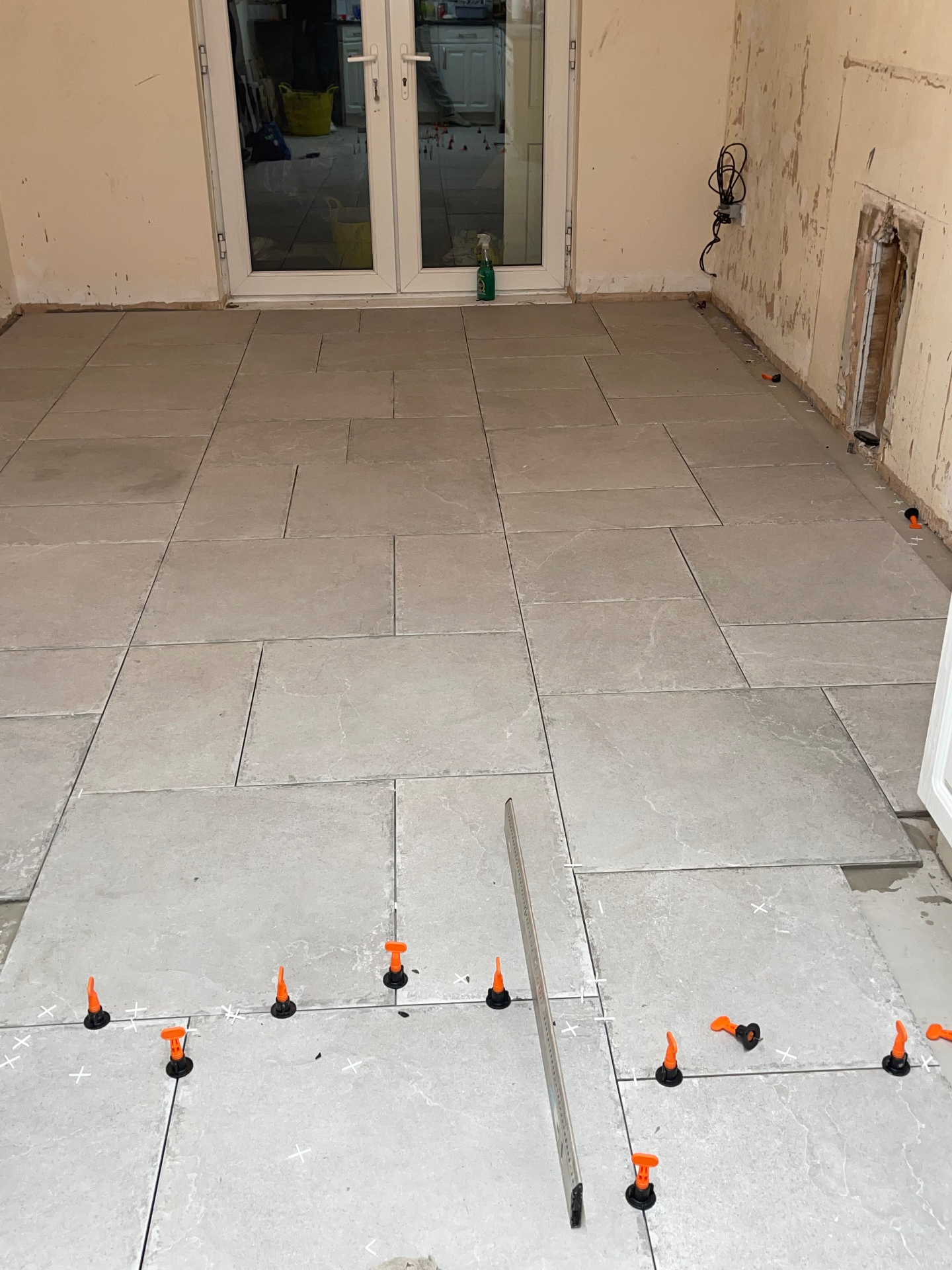 Large-format tiles being levelled with clips during installation