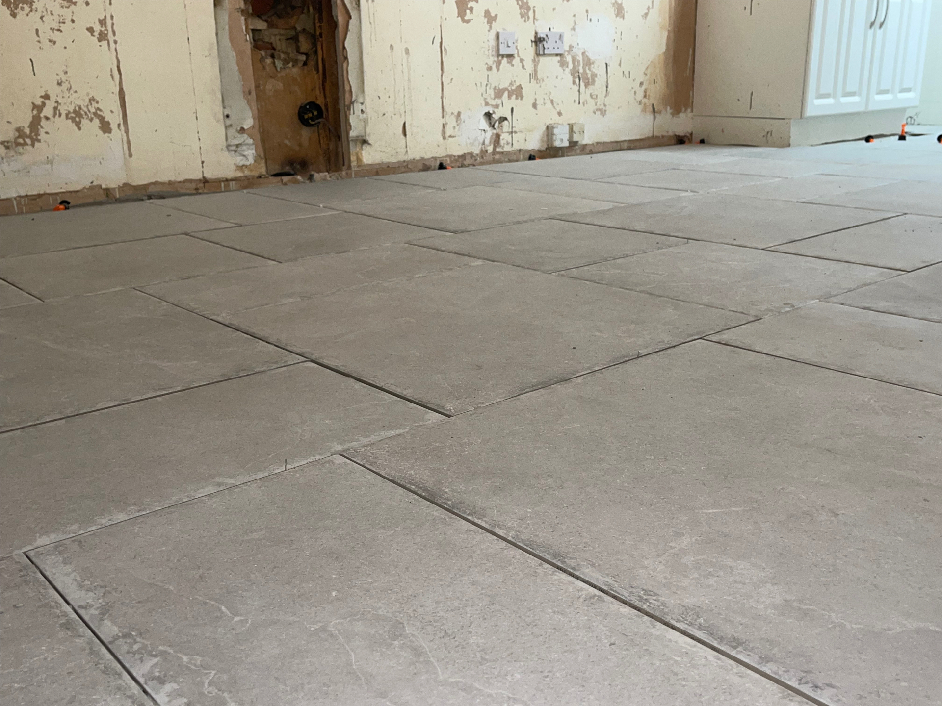 Concrete-effect floor tiles laid over underfloor heating in a Sheffield home